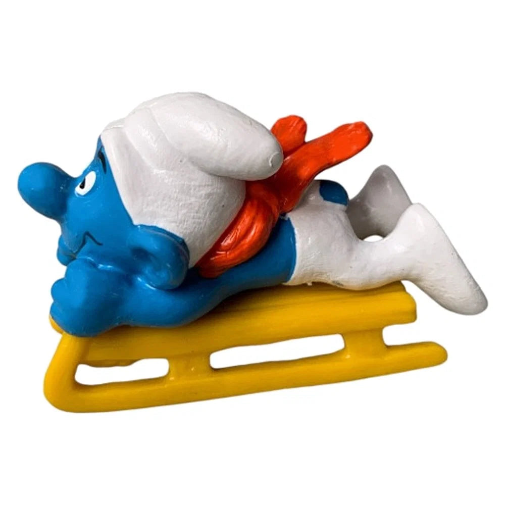 Schleich Super Smurfs Slädsmurfen 40201 med gul släde och handmålade detaljer i originalförpackning.
