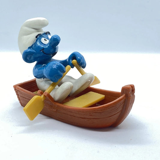 Schleich Super Smurf med roddbåt från 1981 i tysk originalask, samlarfigur märkt Peyo, ca 5,5 cm hög, vintage Smurf-modell.