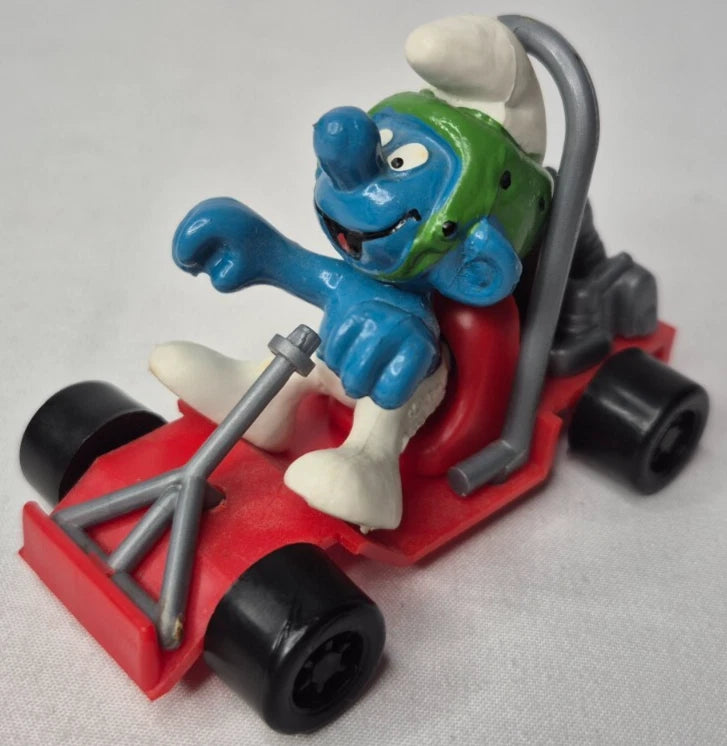 Schleich Super Smurfs Go-Cart Smurfen i originalförpackning, handmålad PVC-figur i mint condition, vintage samlarobjekt.